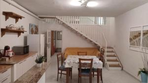 a kitchen and dining room with a table and a staircase at On The Beach SORRENTO in Massa Lubrense +27 photos