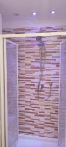 a shower in a bathroom with a wooden wall at On The Beach SORRENTO in Massa Lubrense