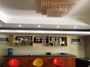 um bar com cadeiras vermelhas e um lustre em Rainbowland Hotel em Olongapo