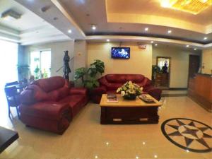 a living room with red leather couches and a coffee table at Rainbowland Hotel in Olongapo