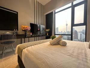 吉隆坡Axon Residence Suites KL的一间卧室设有一张带平面电视的床。 更多27张照片
