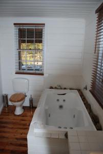 a white bathroom with a tub and a toilet at Mancuso Country Cottage Retreat in Metcalfe