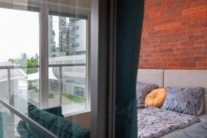 kanapę przy ceglanej ścianie obok okna w obiekcie Golden Apartments-Sok15 w mieście Katowice
