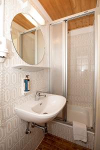 un bagno con lavandino e specchio di Hotel Alpen Arnika a Tauplitzalm