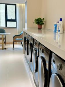 a row of washers and dryers in a room at Jin Jiang West Capital International Hotel the Bell and Drum Tower Muslim quarter & Metro Line 6 & indoor swimming pool & self-service free laundry room in Xi'an