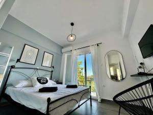 una camera da letto con un letto, uno specchio e una finestra di Alexander apartment 3 a Spartià