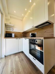 a kitchen with white cabinets and an oven at Apartment Mara&Padrona in Zadar