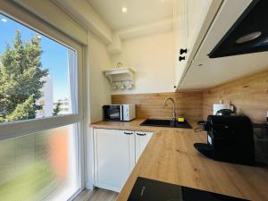 a kitchen with a sink and a microwave and a window at Apartment Mara&Padrona in Zadar