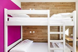 two bunk beds in a room with pink walls at Hostel Link in Lovran