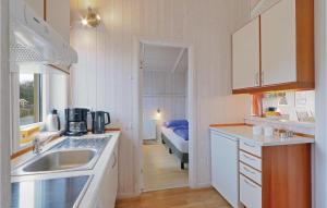 a small kitchen with a sink and a bed at Abendrot 2 - Dorf 3 in Priwall