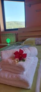 a red flower sitting on top of towels on a bed at Apartma Mimi in Dekani