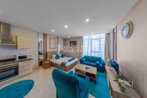a living room with blue chairs and a couch at Vita Tower in Manama
