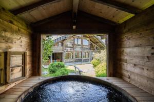 an indoor hot tub in a house with a large window at Chalet Chatel, avec services, Collection Chalets des Fermes - Megève in Megève