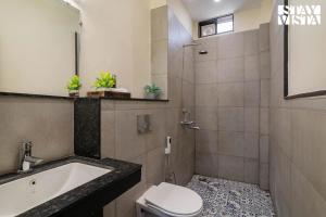a bathroom with a sink and a toilet and a shower at Serenity By The Ganges with Alfresco Dining at Varanasi by StayVista in Varanasi +22 photos