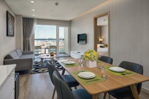 a dining room with a table and a living room at Abogo Apartment FHome Riverside in Da Nang
