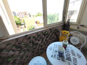 a table in a room with two windows at Fracco's House S. Marinella fronte mare 36' di treno da Roma in Santa Marinella