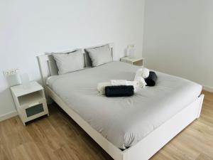a white bed with a stuffed teddy bear on it at Infinito in La Oliva