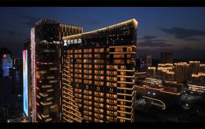 a tall building in a city at night at Quanzhou C&D Hotel Donghai Quanzhou in Quanzhou