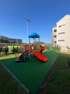 a playground with a slide on a green lawn at Ballito Village Suites in Ballito