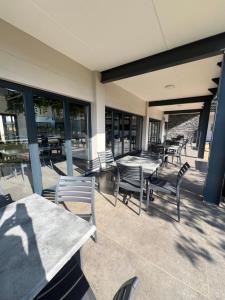 a patio with tables and chairs and windows at Ballito Village Suites in Ballito