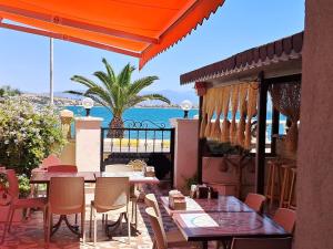 a patio with tables and chairs and a view of the ocean at Sözer Otel in Ayvalık