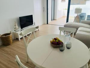 a living room with a white table with a bowl of fruit at Infinito in La Oliva