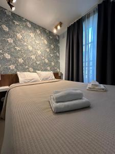 Un dormitorio con una cama con toallas. en MULTIRESIDENCE L'ELYSEE Paris, en París