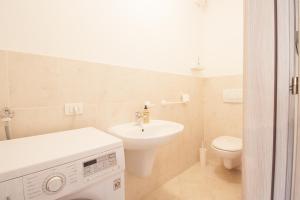 a white bathroom with a sink and a toilet at Casa Diamante in Valdobbiadene