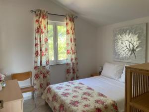 a bedroom with a bed and a window at Apartmani kod Lovrića in Vir