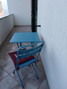 Una mesa azul y una silla junto a una pared. en casa vacanze Lepanto, en Castro di Lecce