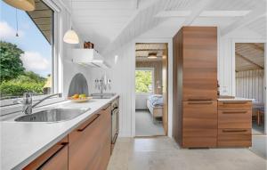 a kitchen with wooden cabinets and a sink at Holiday Home Slivsø Haderslev Ii in Haderslev