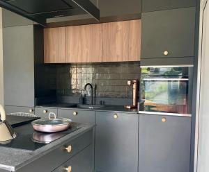 una cucina con armadi in acciaio inossidabile e lavandino di Appartement moderne dominant la ville a Pontarlier Altre 7 foto