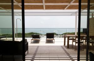 a patio with chairs and a table and a view of the ocean at Hotel Mediterraneo Suite&Residence in Lido di Jesolo +203 photos