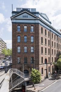 um grande edifício de tijolos com uma ponte em frente em The Woolstore 1888 em Sydney