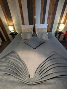 a large bed in a room with two lamps at Chez les Martin in Castelnau-de-Médoc