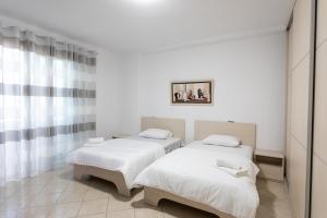 duas camas em um quarto com paredes brancas em Durres Port View Apartment em Durrës