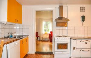 a kitchen with orange and white appliances and a living room at Amazing Home In Årjäng With Wifi in Årjäng +7 photos