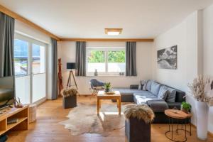 a living room with a couch and a tv at Haus Floria Top 2 in Neukirchen am Großvenediger