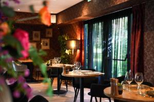 a restaurant with tables and chairs and a large window at Hotel Het Witte Paard in Etten-Leur
