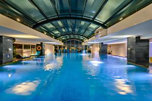 a swimming pool with blue water and a glass ceiling at Abogo Apartment FHome Riverside in Da Nang