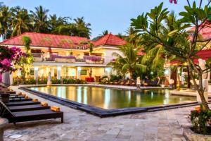 a resort with a pool in front of a building at Lintang 1 BR Superior Room JU46 in Mataram