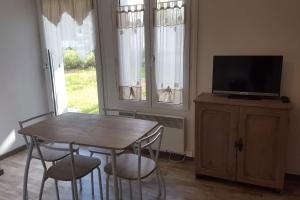 Un comedor con mesa y sillas y un televisor. en Studio city center, en Les Rousses