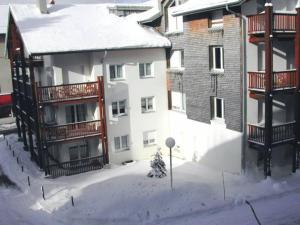 Un edificio de apartamentos con nieve en el suelo. en Studio city center, en Les Rousses