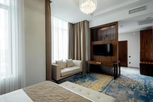a hotel room with a bed and a television at Qazaq Hotel Premium in Shymkent