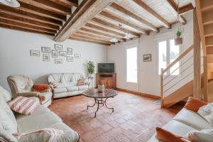a living room with a couch and a table at Maison de Marcelline - Pour 10p maison climatisée in La Lande-Chasles