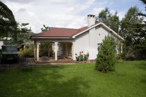 a white house with a red roof at Coffee Farm Guest House in Nkoaranga