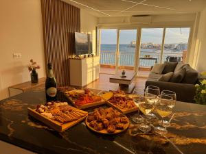 einen Tisch mit einem Haufen Essen und Gläsern Wein in der Unterkunft Luxury apartament Luz Mar in playa de los Locos in Torrevieja + 20 Fotos