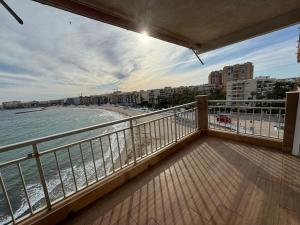 einen Balkon mit Blick auf den Strand und die Gebäude in der Unterkunft Luxury apartament Luz Mar in playa de los Locos in Torrevieja