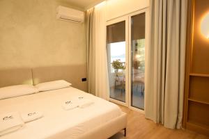 a bedroom with a bed and a large window at Lungomare ViewPoint in Vlorë