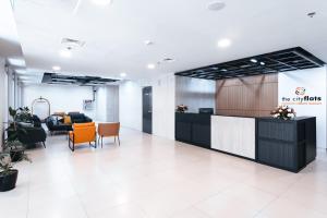 an office lobby with a reception desk and chairs at The City Flats Circuit in Manila